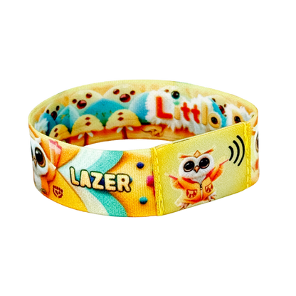 Static photo of the wristband’s front, displaying the square green NFC tag with a teal-hooded owl icon, framed by a vibrant print of pom-poms, palms, and confetti on a green band.